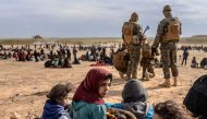 Civilians evacuated from the Islamic State (IS) group's embattled holdout of Baghouz wait at a screening area held by the US-backed Kurdish-led Syrian Democratic Forces (SDF), in the eastern Syrian province of Deir Ezzor, on March 5, 2019.   AFP / Bulent 