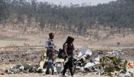 A Kenyan woman looks at debris of the Ethiopian Airlines Flight ET 302 plane crash after a commemoration ceremony at the scene of the crash, near the town of Bishoftu, southeast of Addis Ababa, Ethiopia March 13, 2019. REUTERS/Baz Ratner