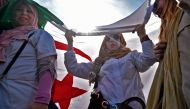 A woman holds her national flag as Algerian teachers protest in central Algiers on March 13, 2019 against President Abdelaziz Bouteflika's bid to prolong his two-decade rule. AFP / RYAD KRAMDI