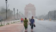 People drenched in the rain walk near India Gate during a heavy monsoon downpour in New Delhi on July 5, 2018. AFP/Prakash Singh