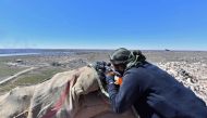 A sniper with the Syrian Democratic Forces (SDF) opens fire toward a part of Baghouz where remaining Islamic State (IS) group fighters are holding out in their last position, in the countryside of the eastern Syrian province of Deir Ezzor on March 18, 201