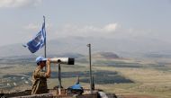 A United Nations Truce Supervision Organisation military observer uses binoculars near the border with Syria in the Israeli-occupied Golan Heights, May 11, 2018. Reuters/Baz Ratner