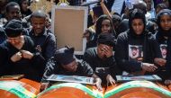 Mourners of victims of the crashed accident of Ethiopian Airlines react beside coffins during the mass funeral at Holy Trinity Cathedral in Addis Ababa, Ethiopia, on March 17, 2019. AFP / Samuel HABTAB