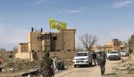A Syrian Democratic Forces flag flutters on a damaged building in the village of Baghouz, Deir Al Zor province, Syria, March 23, 2019. REUTERS