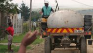 Residents greet workers collecting buckets of raw sewage from homes in the Ezenzeleni township, about 200 km (124 miles) south of Johannesburg, February 8, 2006. Reuters/Siphiwe Sibeko