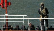 A Maltese special forces soldier guards a group of migrants on the merchant ship Elhiblu 1 after it arrived in Senglea, in Valletta's Grand Harbour, Malta, March 28, 2019. REUTERS/Darrin Zammit Lupi