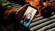 A sister of suspected militant Owais Malik shows a picture of him on her phone at her home in Kashmir's Kulgam district on Feb. 16. Reuters