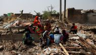 People sit on the rubbles of the houses destroyed by a storm at Bara district, Nepal April 1, 2019. REUTERS/Navesh Chitrakar
