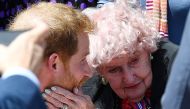 (FILES) In this file photo taken on October 16, 2018, Britain's Prince Harry hugs 98-year old war widow Daphne Dunn as he walks outside the Sydney’s Opera House to meet people. AFP / SAEED KHAN