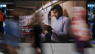 Commuters walk past an advertisement discouraging the dissemination of fake news at a train station in Kuala Lumpur, Malaysia, March 28, 2018. (Reuters) 