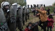 A woman clashes with Greek riot police outside of a refugee camp in Diavata, a west suburb of Thessaloniki, where migrants gather on April 5, 2019. Hundreds of migrants and refugees gathered following anonymous social media calls to walk until the Norther