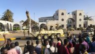 Sudanese protesters flash the victory sign at a passing military vehicle as they gather for a second day outside the military headquarters in the capital Khartoum on April 7, 2019. AFP / -
