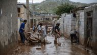 Men clear away mud following floods in the Iranian city of Mamulan in Lorestan province on April 7, 2019.  AFP / HOSSEIN MERSADI