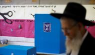 A man walks next to a voting booth and ballot box at a polling station as Israelis vote in a parliamentary election, in Jerusalem April 9, 2019. REUTERS/Ronen Zvulun