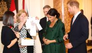 (FILES) In this file photo taken on March 11, 2019 Meghan, Duchess of Sussex (2R) and Britain's Prince Harry, Duke of Sussex (R), react as they are presented with baby gifts by Canadian High Commissioner to the United Kingdom, Janice Charette (2L), at Can
