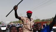 Sudanese men chant slogans along with a soldier in the capital Khartoum. (AFP)