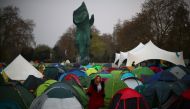A climate change activist walks between tents during an Extinction Rebellion protest at Marble Arch in London, Britain April 16, 2019. REUTERS/Hannah McKay
