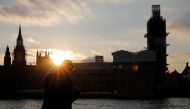A man stands on the banks of River Thames across from the Houses of Parliament in Westminster in central London on March 27, 2019. AFP/Tolga Akmen
