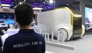 This photo taken on April 17, 2019 shows a Toyota staff member looking at a Toyota e-Calm 01 autonomous vehicle at the Shanghai Auto Show in Shanghai. AFP / Greg Baker