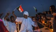 A Sudanese bridegroom waves a Sudan national flag on a wedding car during a protest outside the army complex in the capital Khartoum on April 20, 2019. AFP / OZAN KOSE