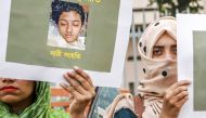 Bangladeshi women hold placards and photographs of schoolgirl Nusrat Jahan Rafi at a protest in Dhaka, following her murder by being set on fire after she had reported a sexual assault, on April 12, 2019. AFP / Sazzad Hossain 