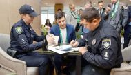 Volodymyr Zelensky being fined by police for showing his marked ballot paper to the public at a polling station in Kiev on April 21, 2019 thus violating the voting rules protocol.  AFP/Volodymyr Zelensky press service handout