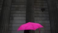 A woman carries an umbrella during a rain shower as she walks past the Bank of England in London, November 30, 2009. Reuters/Andrew Winning