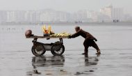 A man pushes a cart as he sells cooked corn on Clifton beach in Karachi, Pakistan, February 20, 2019. Reuters/Akhtar Soomro