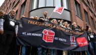 Representatives of Amazon workers hold a banner reading 