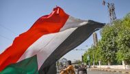 A Sudanese protesterr waves a national flag near a makeshift barricade during an a sit-in outside the army headquarters in the capital Khartoum on April 30, 2019.  AFP / OZAN KOSE