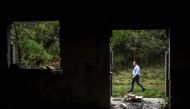 Jovan Plaku, 45, walks on April 22, 2019 on a former military base in the Dajti mountain near Tirana, where he believes his father was buried after he was killed by the communism regime on June 1977.  AFP / Gent Shkullaku 