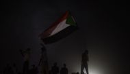 Sudanese protesters wave national flags at the sit-in outside the army headquarters in Khartoum on May 9, 2019. / AFP / Mohamed el-Shahed
