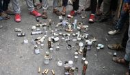 Kashmiri protesters stand around empty shells and canisters fired by Indian government forces during clashes at Mirgund Pattan on the outskirts of Srinagar on May 13, 2019, as protesters called for justice in the case of the alleged rape of a three-year-o