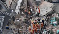 Members of a rescue team work at the site of a building collapse in Shanghai on May 16, 2019. AFP / Hector RETAMAL