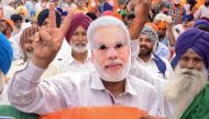 File photo of an Indian BJP supporter wearing a mask of Indian Prime Minister Narendra Modi gestures during an election rally in Amritsar on May 12, 2019. / AFP / NARINDER NANU 