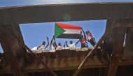 Sudanese protesters wave a national flag near the military headquarters in the capital Khartoum on May 17, 2019, during an ongoing sit-in demanding a civilian-led government transition. AFP / MOHAMED EL-SHAHED