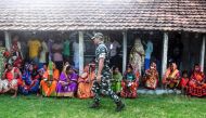 Indian voters sit as they queue to cast their vote as paramilitary personnel stand guard in the Ghoramara island around 110 km south of Kolkata on May 19, 2019, during the 7th and final phase of India's general election. AFP / DIBYANGSHU SARKAR