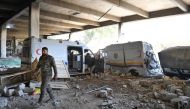 A Syrian government soldier walks past destroyed ambulances and vehicles of the Syrian Civil Defence, also known as 
