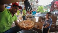 A Syrian vendor prepares sweets at a market in the capital Damascus on May 19 , 2019, during the Muslim holy fasting month of Ramadan. / AFP / LOUAI BESHARA