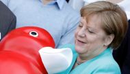German Chancellor Angela Merkel receives a duck toy as she visits biotech company Centogene in Rostock, Germany May 23, 2019. REUTERS/Michele Tantussi