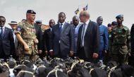 FILE PHOTO: French Defence Minister Jean-Yves Le Drian flanked by President of the Central African Republic Faustin-Archange Touadera looks at military supplies at the Mpoko military base in Bangui on October 31, 2016. AFP