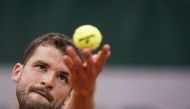 Bulgaria's Grigor Dimitrov serves to Serbia's Janko Tipsarevic during their men's singles first round match on day 1 of The Roland Garros 2019 French Open tennis tournament in Paris on May 26, 2019. / AFP / Kenzo TRIBOUILLARD