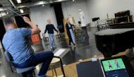 A soccer match is played as Riccardo Massi (L) and Keri Alkema rehearse for the upcoming Washington National Opera (WNO) production of Tosca at WNO's Studio Workroom on April 29, 2019 in Washington, DC.  AFP / Andrew Caballero-Reynolds