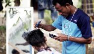 A Rohingya refugee cuts the hair of a kid at a temporary shelter in Beras Pati after having arrived from Aceh Shelter in Medan of North Sumatra, Indonesia on November 25, 2016. Jefri Tarigan/Anadolu Agency