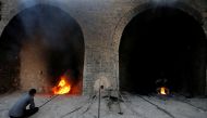 An Iraqi worker checks a chimney stack outlets at the brick factory in the town of Nahrawan in Baghdad, Iraq June 3, 2019. Reuters/Thaier al-Sudani