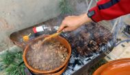 A fighter loyal to the Libyan internationally-recognised Government of National Accord (GNA) prepares the Iftar meal for fellow fighters before breaking their fast at the front lines on MAY 31, 2019, in the suburb of Al-Swani, 25 kilometres south of Tripo