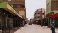 A Sudanese woman walks past closed shops in a commercial street in Khartoum's twin city Omdurman on the first day of a civil disobedience campaign across Sudan on June 9, 2019.  AFP