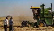 A picture taken on May 21, 2019, shows a combine harvester harvesting a wheat field in Syria's northeastern region of Hasakeh. AFP / DELIL SOULEIMAN
