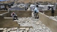 Workers demolishing a concrete shelter at a refugee camp in the northeastern Lebanese town of Arsal, in the Bekaa valley. AFP / JOSEPH EID