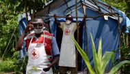 Health workers stand at a non-gazetted crossing point in the Mirami village, near the Mpondwe border checkpoint between Uganda and the Democratic Republic of Congo on June 14, 2019. AFP / ISAAC KASAMANI